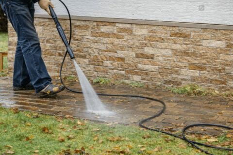 Man Power Washing Brick Sidewalk