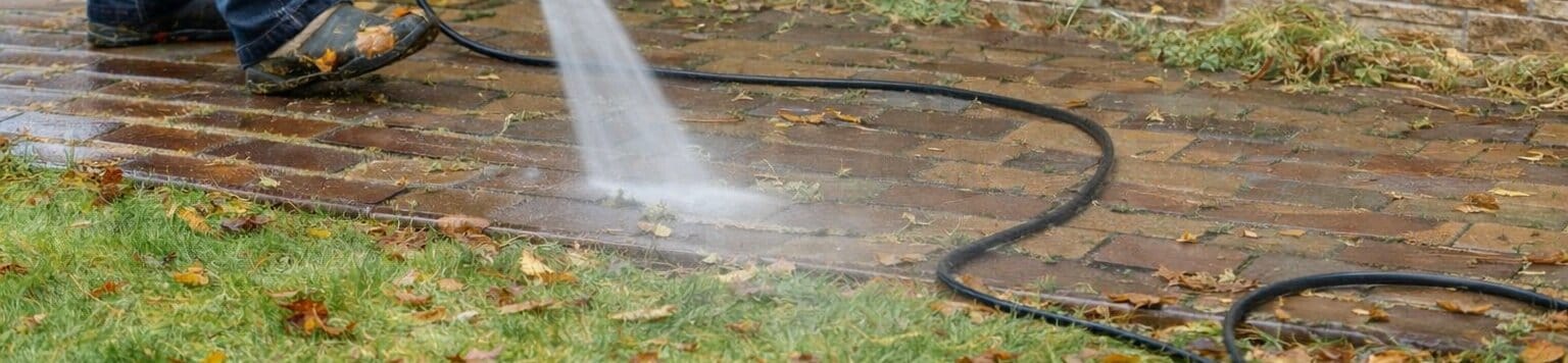 Man Power Washing Brick Sidewalk Wide Angle