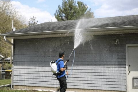 Man Pressure Washing Dirty Gutters